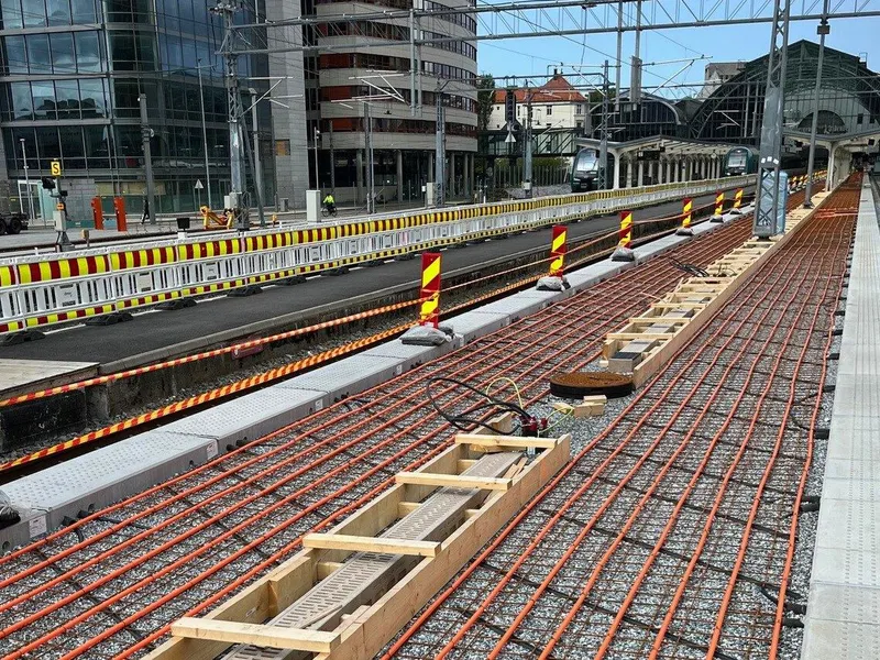 Oransje rør i grus ved siden av betongelementer på togperrong