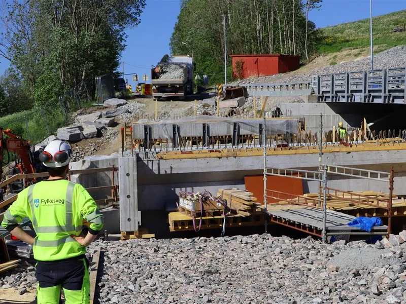 Byggeplass. Mann i verneklede og hjelm. - Klikk for stort bilete