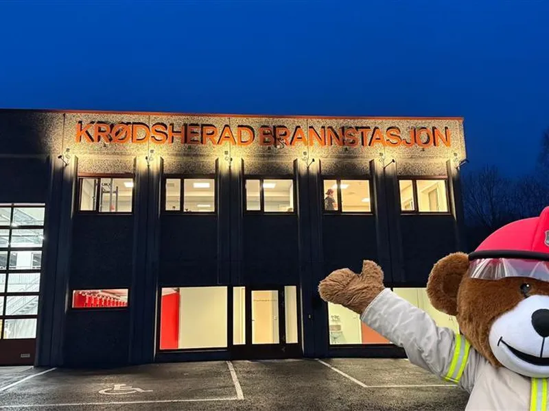 Brannstasjonsbygg med en bamse i høyre hjørne - Klikk for stort bilde