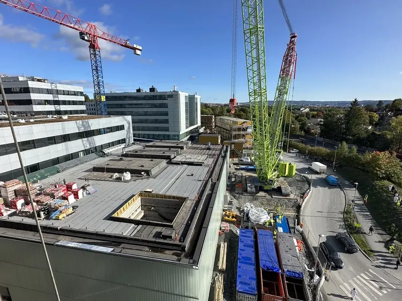 En byggeplass med kraner og bygninger