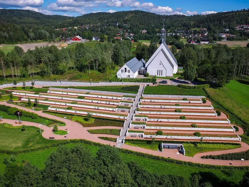 Dronebilde tatt skrått ovenfra av Lommedalen kirke og gravlund