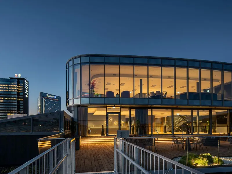 Sixa med de to øverste etasjene sett fra utsiden hvor vi ser eksteriøret med vinduer fra gulv til tak og en stor terrasse foran.