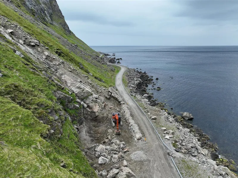 Smal veg mellom fjord og fjell. Anleggsarbeid. Foto.  - Klikk for stort bilde