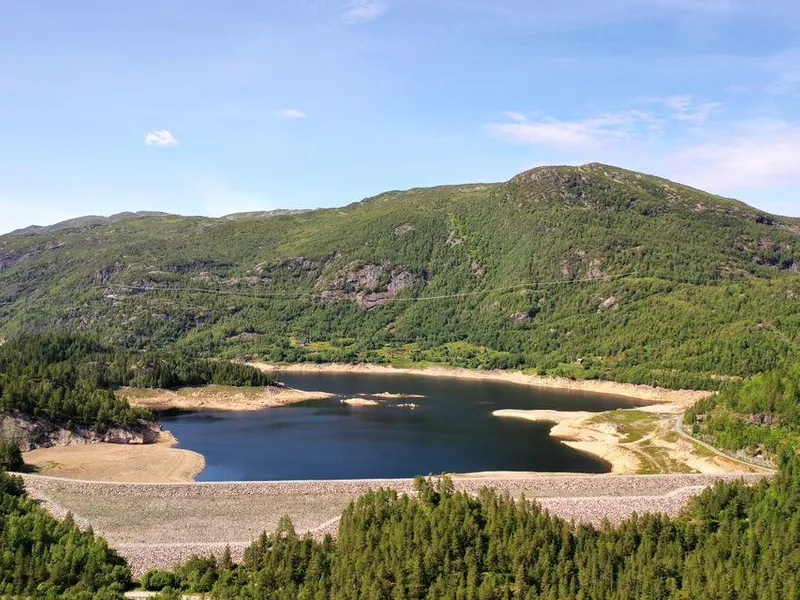 Dam, vann, skog, himmel. Foto.