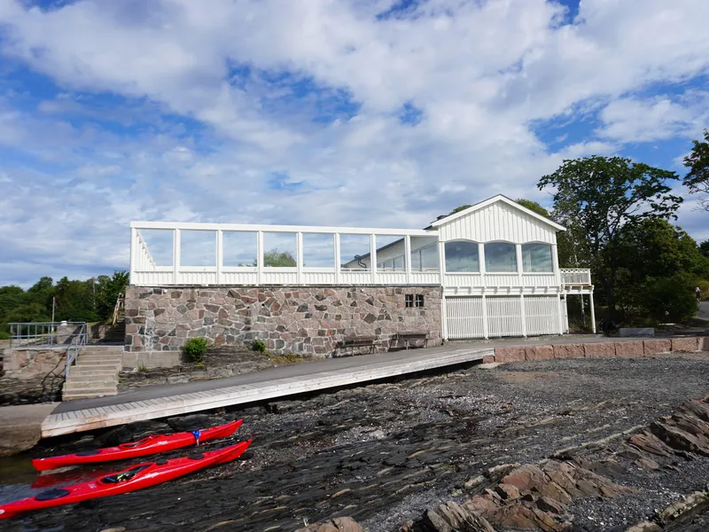 Fasade av Hukodden strandrestaurant, som viser terrassen ved strandsonen.