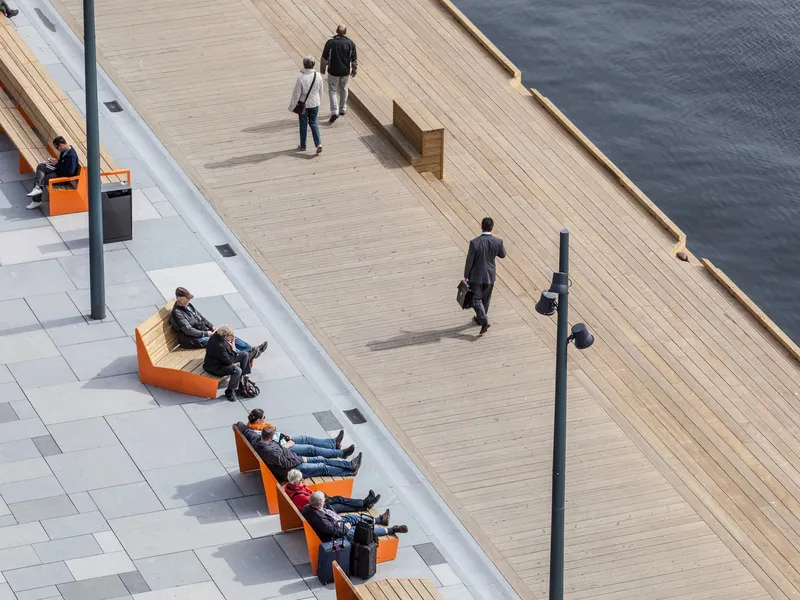 Møblert kaipromenade med materialer i stein og tre. Foto