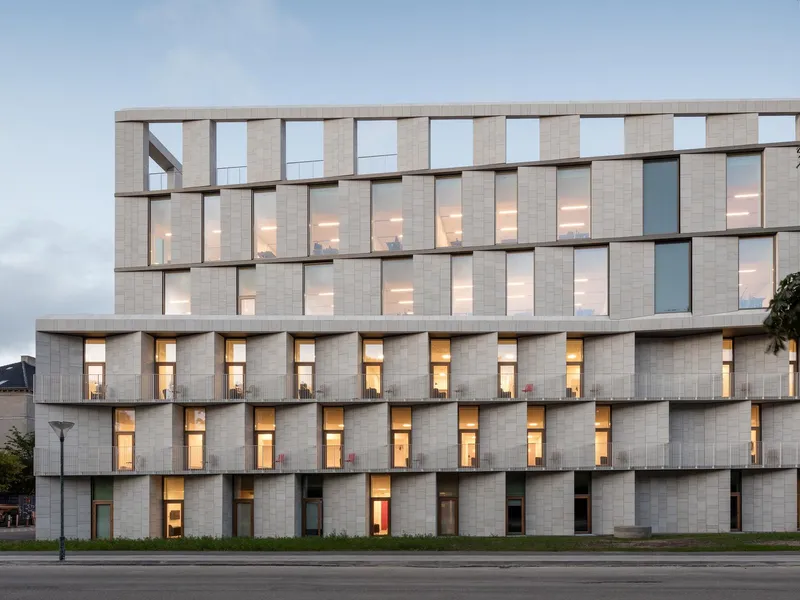 Skulpturel facade i lys sten. Foto