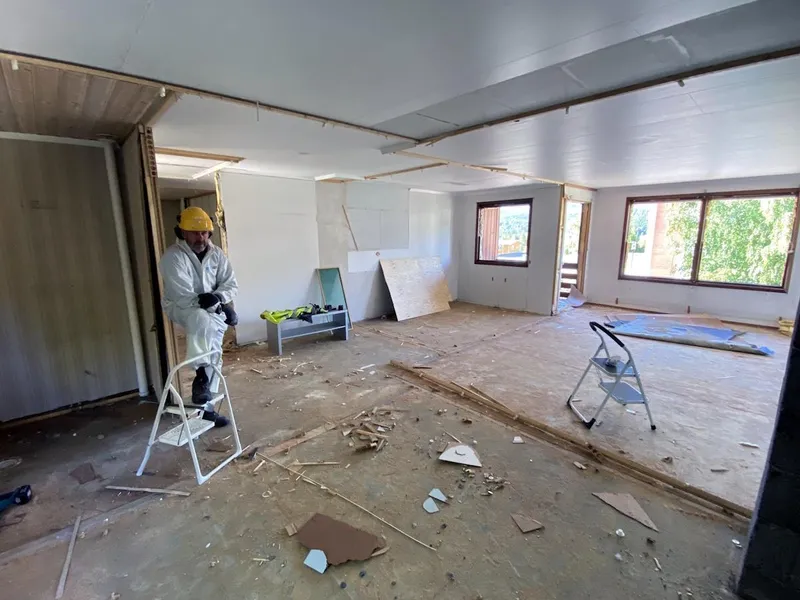 En bygningsarbeider står inne i ei rivningsklar leilighet - Klikk for stort bilde