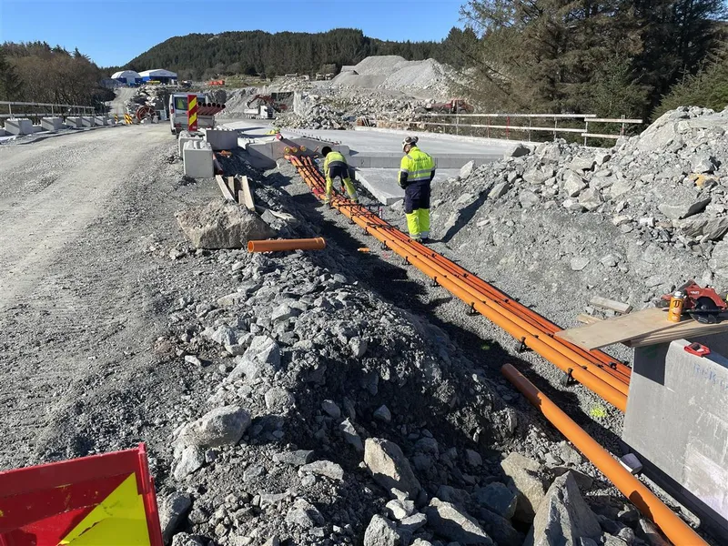 Bildet viser arbeid med trekkerøyr og grøfter ved Laupland.  - Klikk for stort bilete