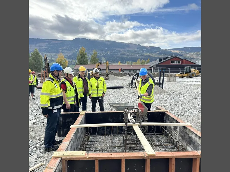 En mann med spade og fem andre som står og ser på - Klikk for stort bilde