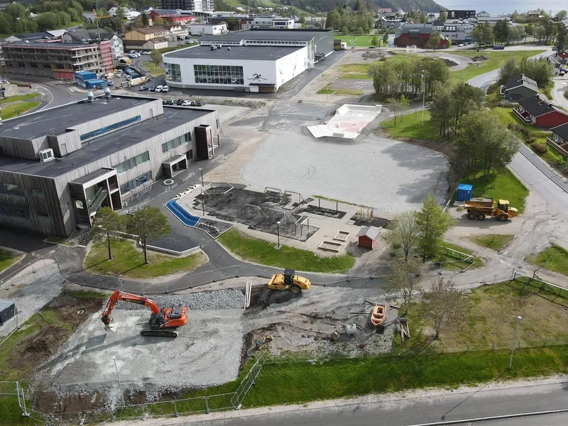 Dronebilde av området ved Kolvereid skole og Nærøysund arena med gravemaskin og veivals i front.  - Klikk for stort bilde