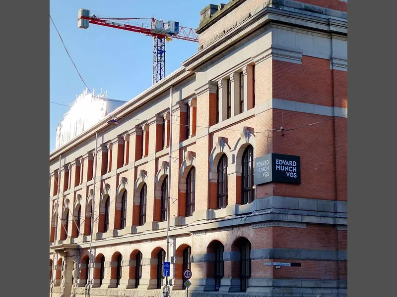 bilde av skolebygg i teglstein med søyler 