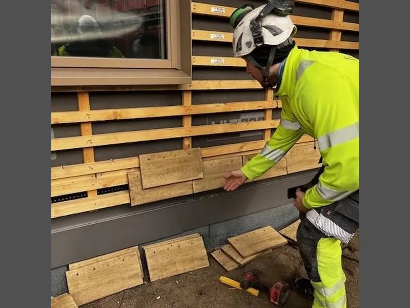 mann som monterer skjermtegl på vegg