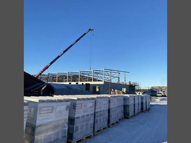 Blå himmel, byggematerialer og kran på uteområdet hos Nekton - Klikk for stort bilde