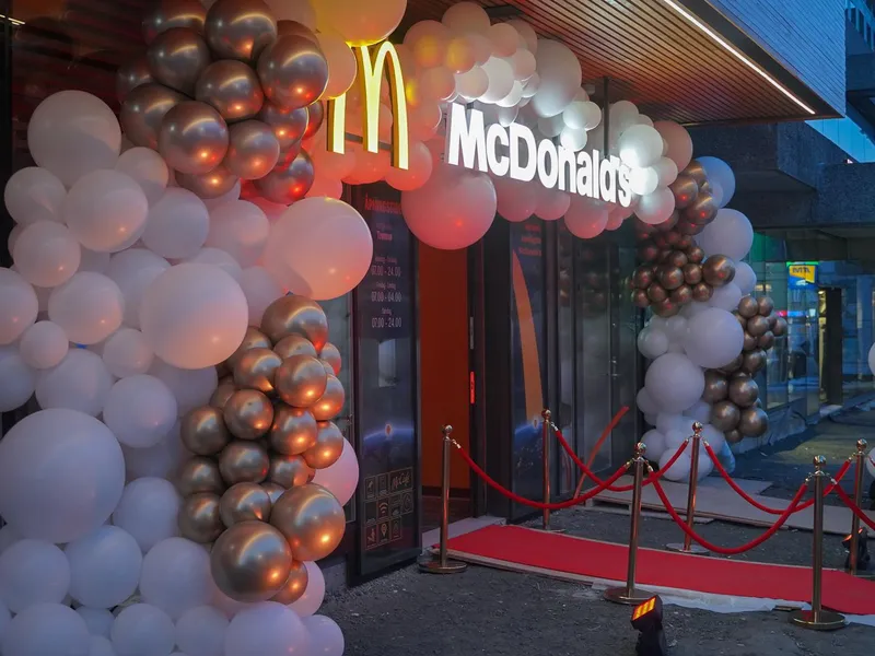 Festlig dekorasjon med ballonger og rødløper utenfor McDonald's restaurant. Foto