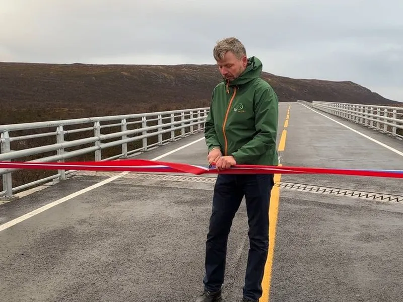 Statssekretær Stein Mathisen klipte snora og åpnet den nye vegstrekningen på E6 i Finnmark med ny bru over Vuolmmašjohka.