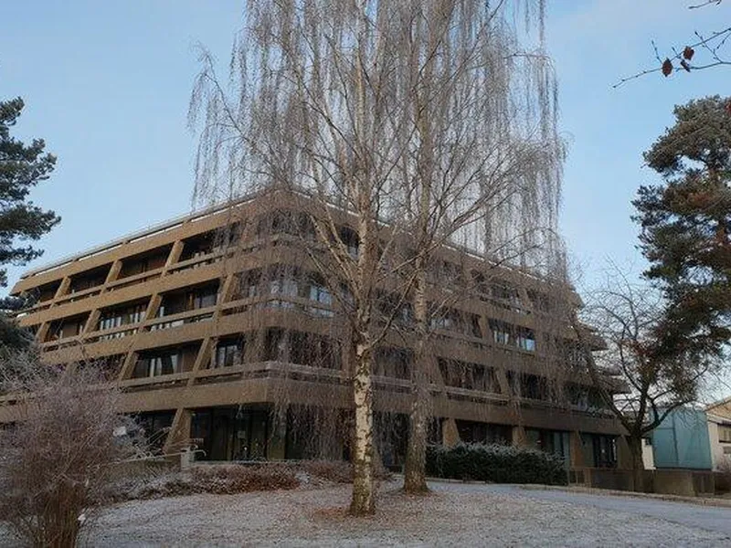 Vinklet visning av gamle Oppegård rådhus omgitt av furu og bjørk i kalde omgivelser